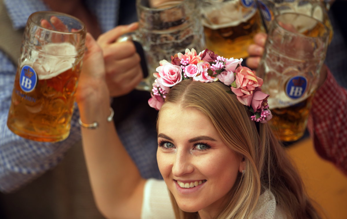 Frau mit Blumenkranz und Bier