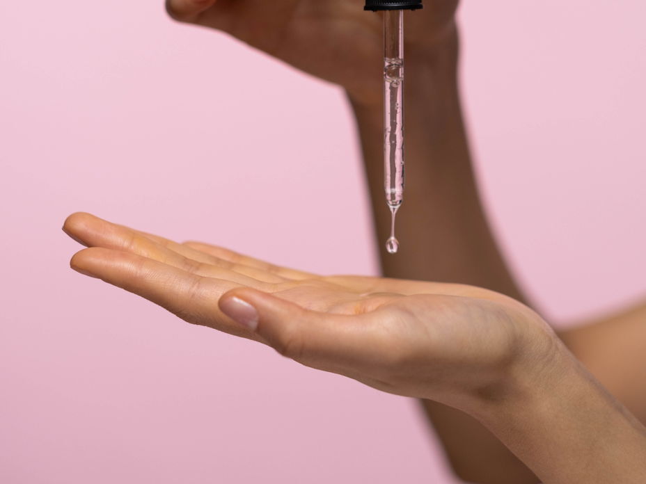 Hände tragen Serum auf