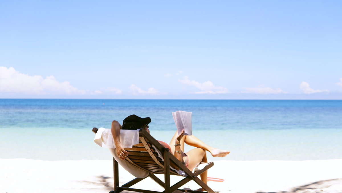 Frau liest Buch am Strand