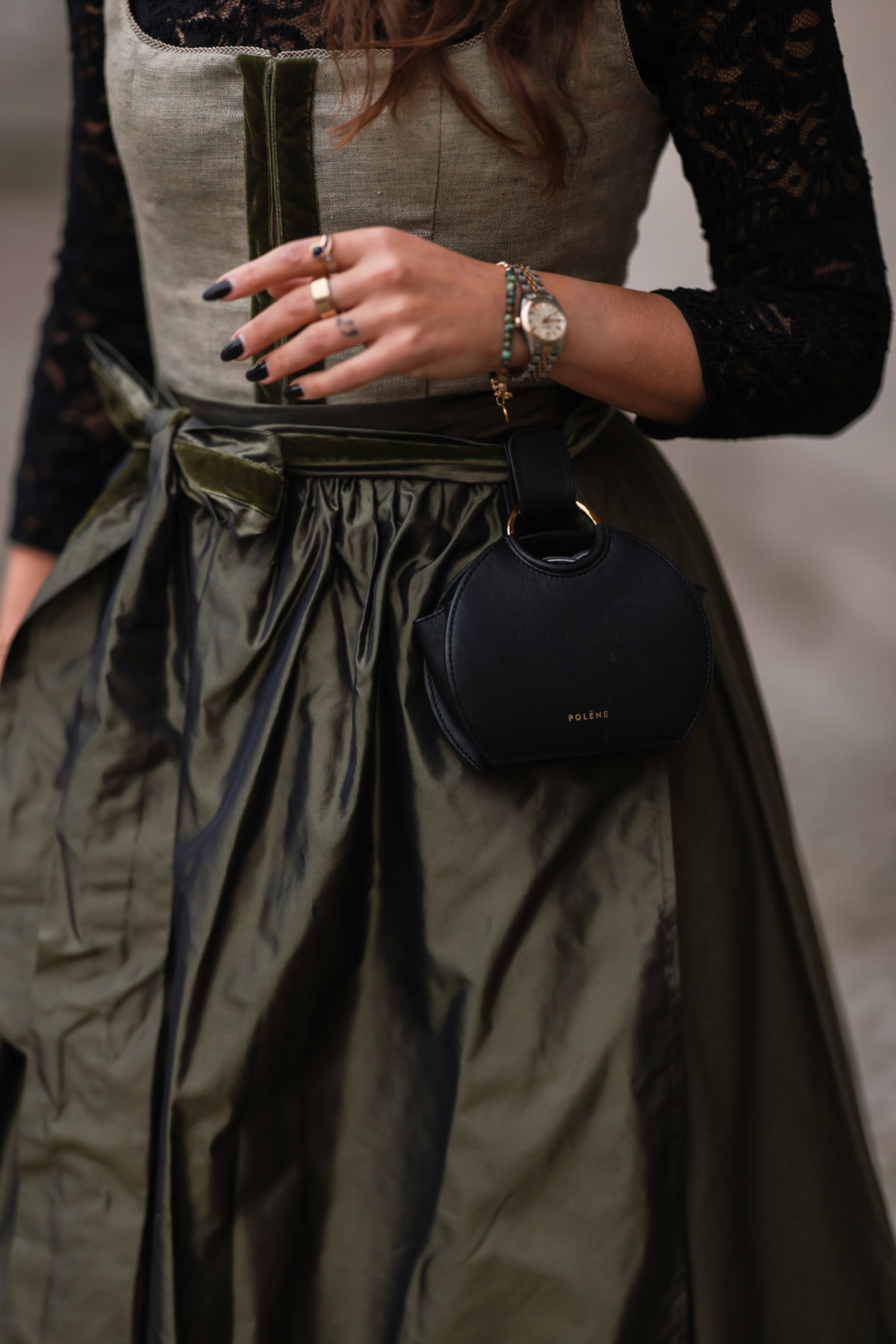 Eine Frau trägt eine Tasche zum Dirndl