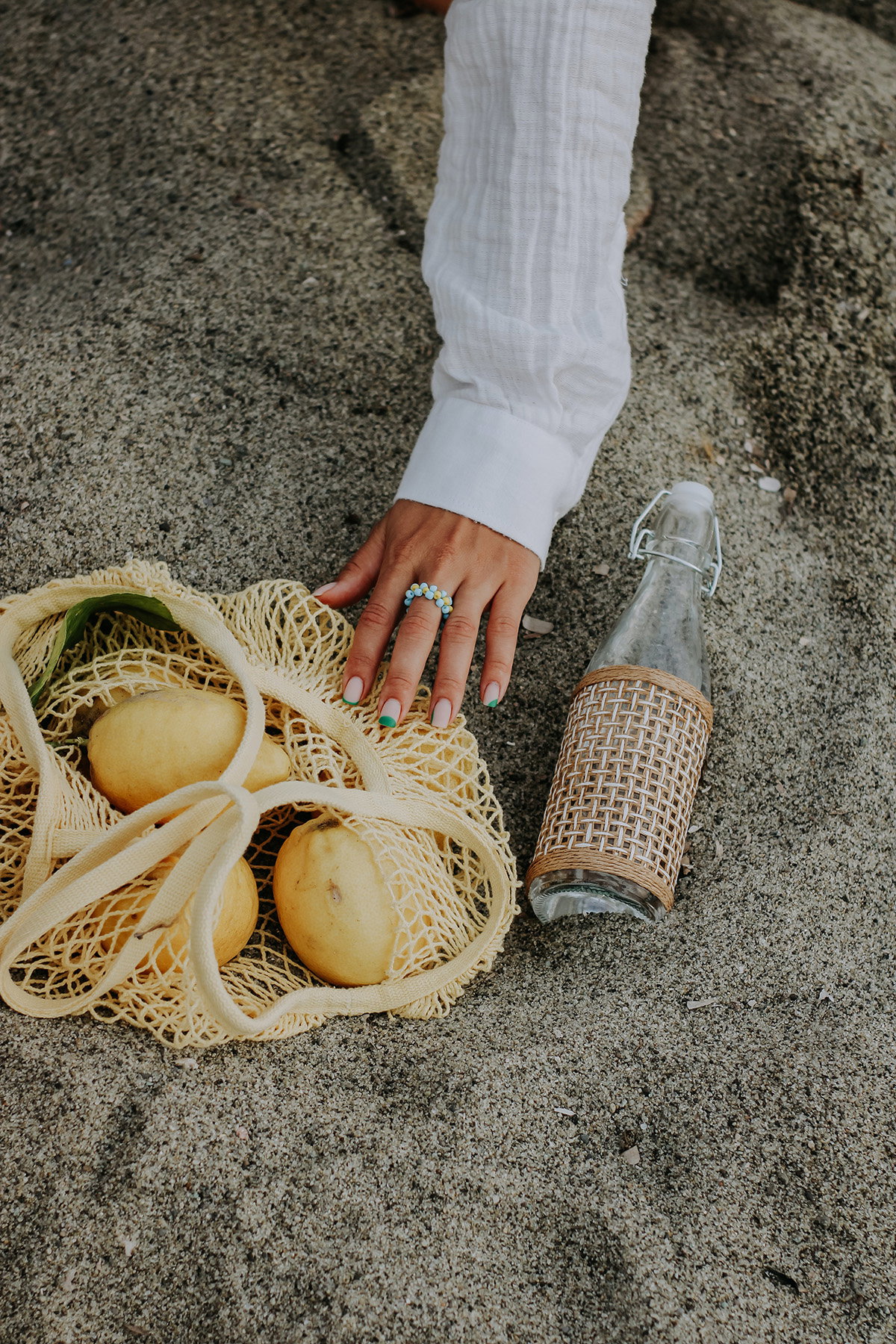Ring am Finger und Zitrone am Strand
