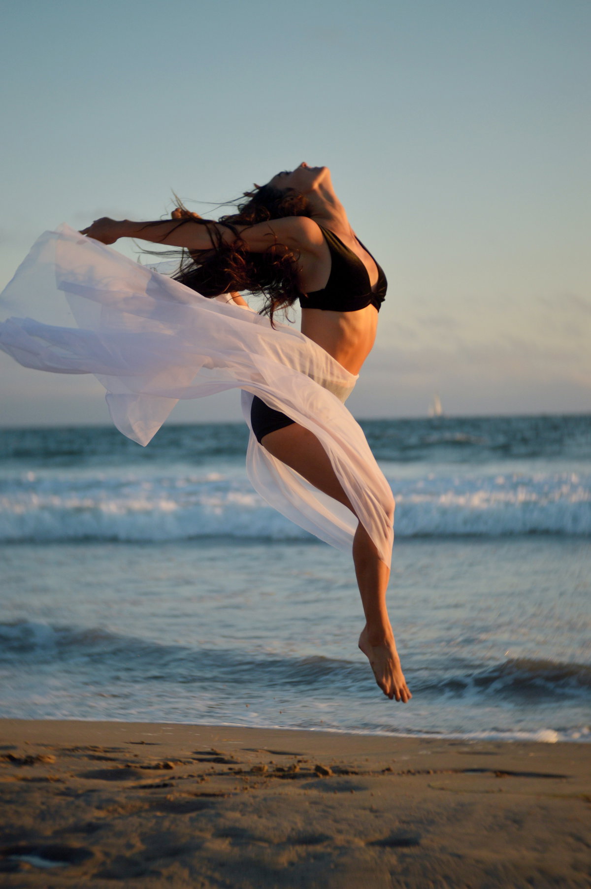 Frau springt am Strand