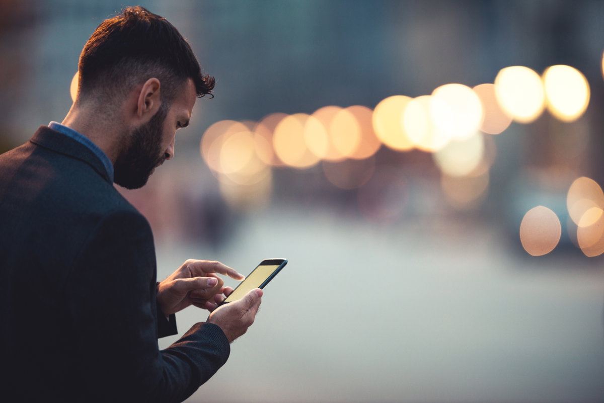 Mann schaut traurig auf Handy