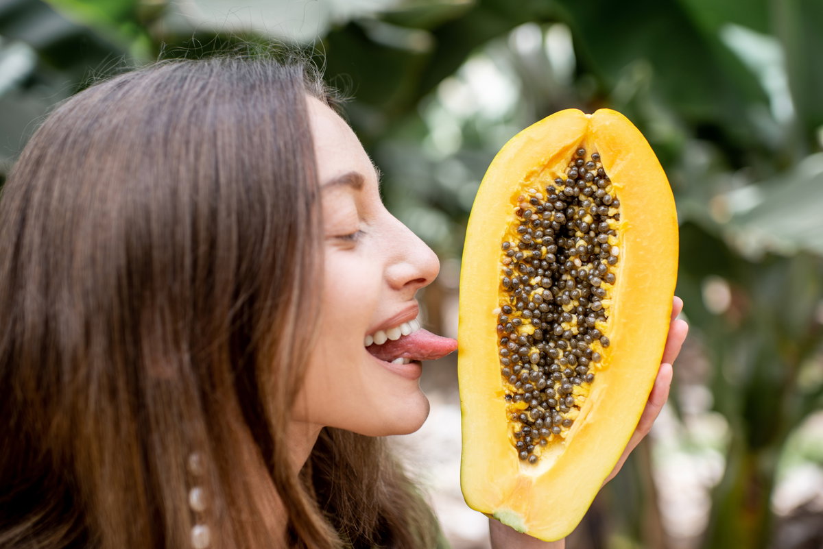Frau leckt Papaya