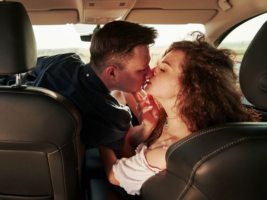 Mann und Frau küssen sich im Auto