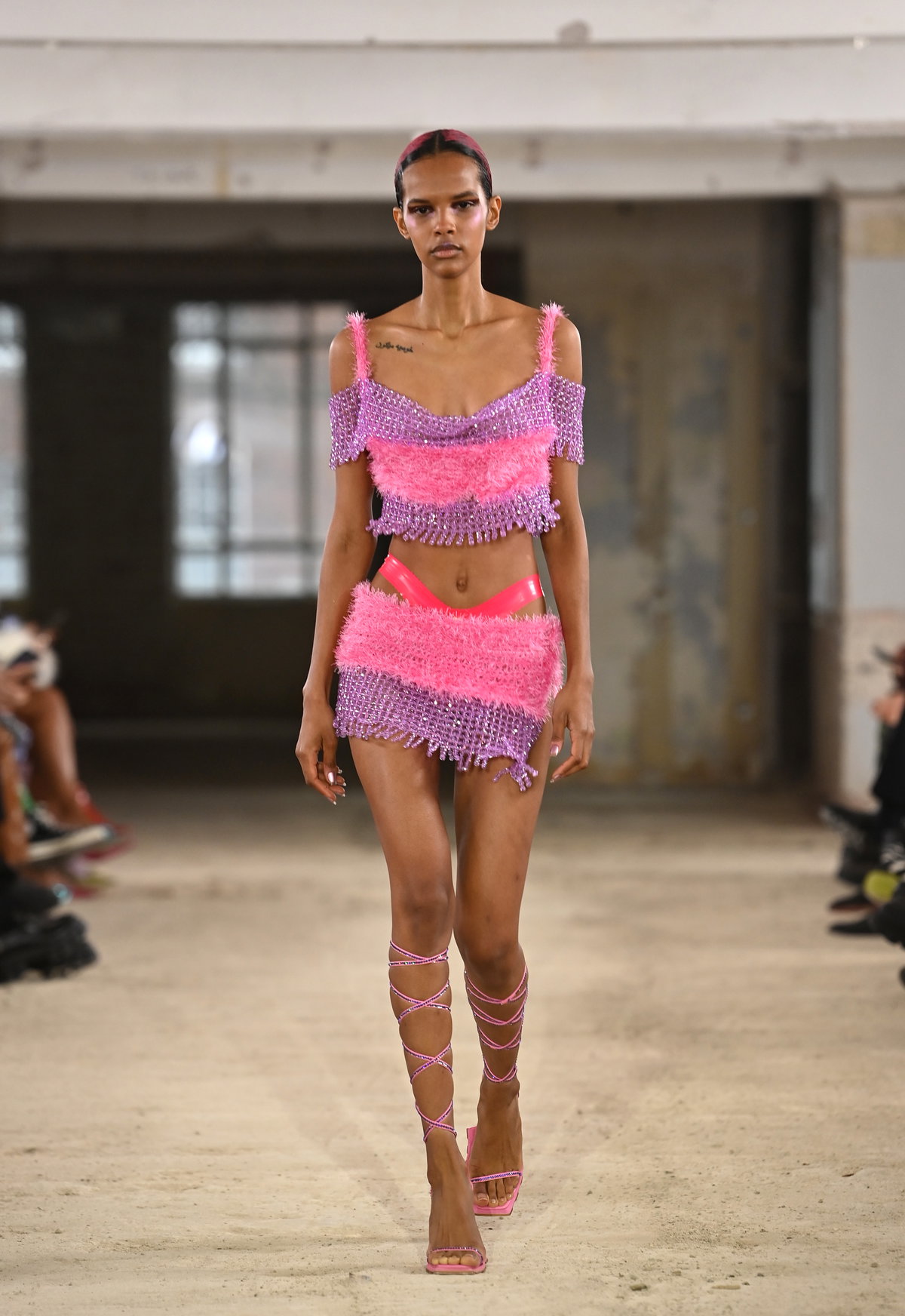 Model auf Laufsteg in pinkem Outfit