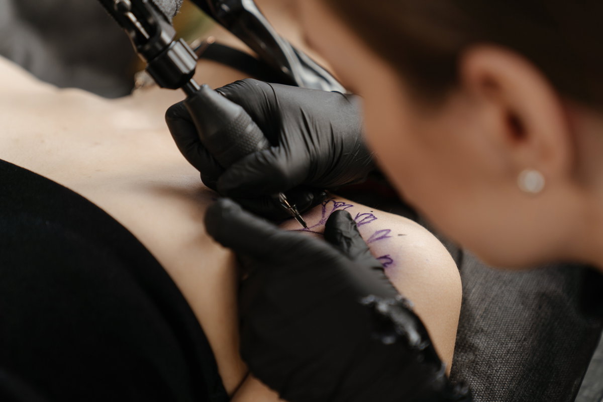 Frau lässt sich Tattoo stechen