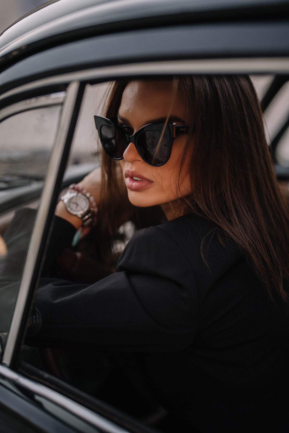 Frau mit Sonnenbrille sitzt im Auto