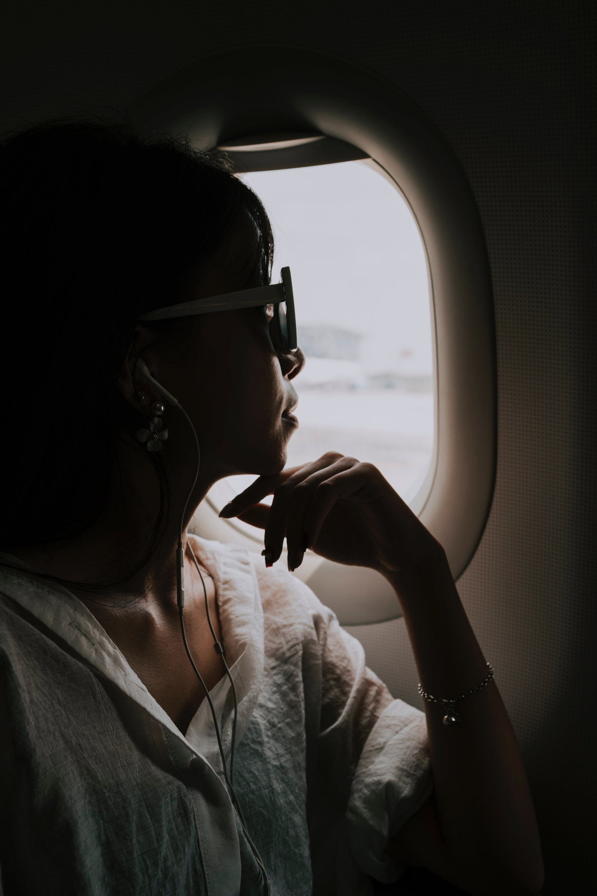 Frau sitzt im Flugzeug am Fenster