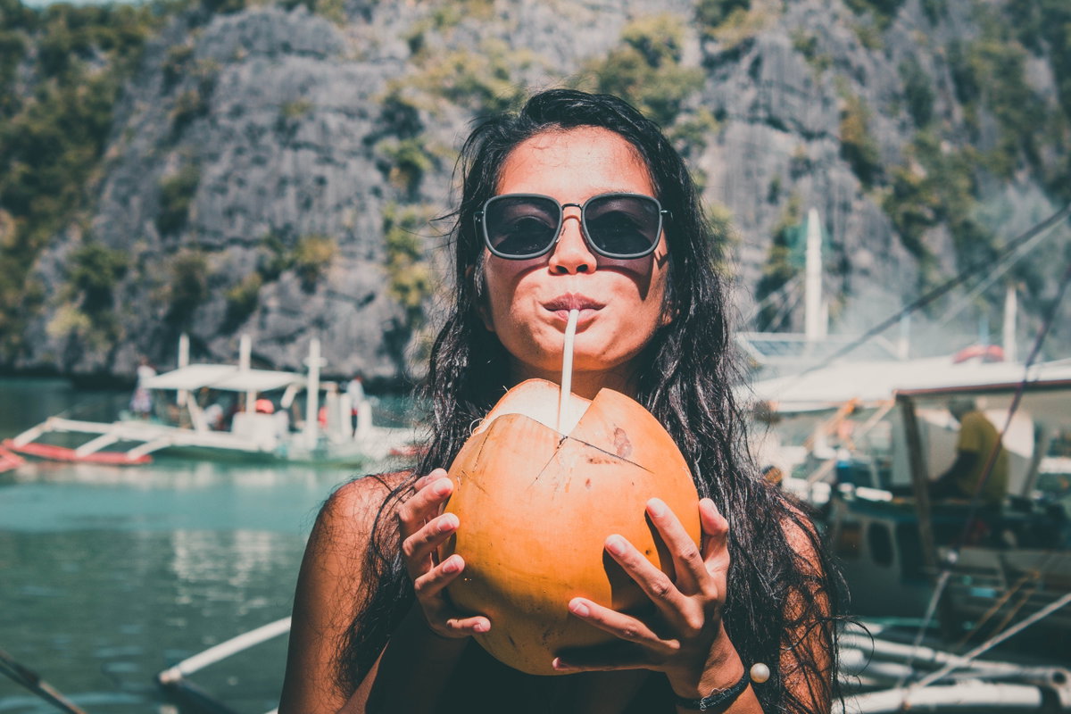 Frau trinkt Kokosnuss