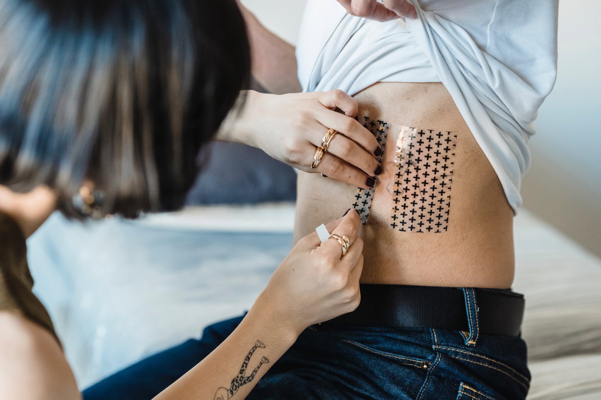 Folie vom Rippen-Tattoo wird abgezogen
