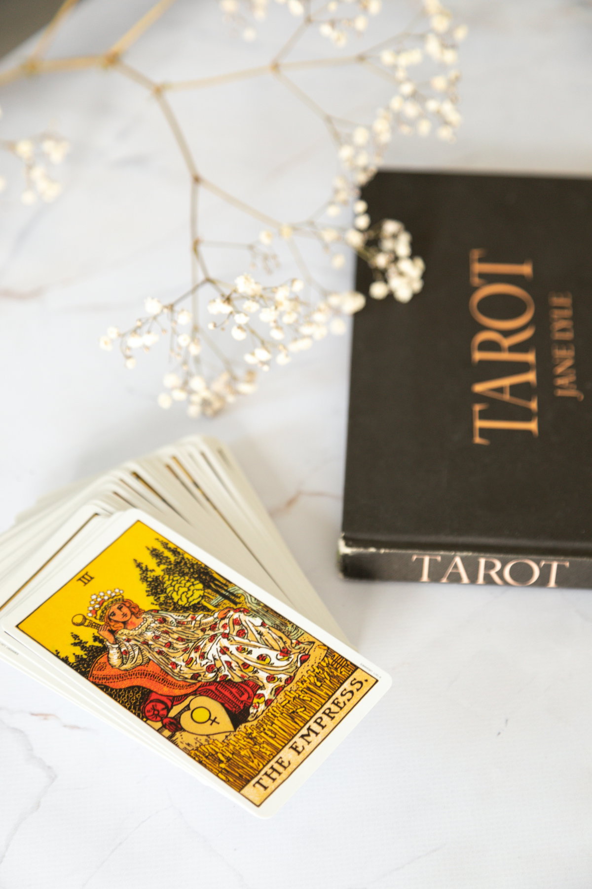 Tarot karten und ein Tarot Buch liegen auf einem Tisch