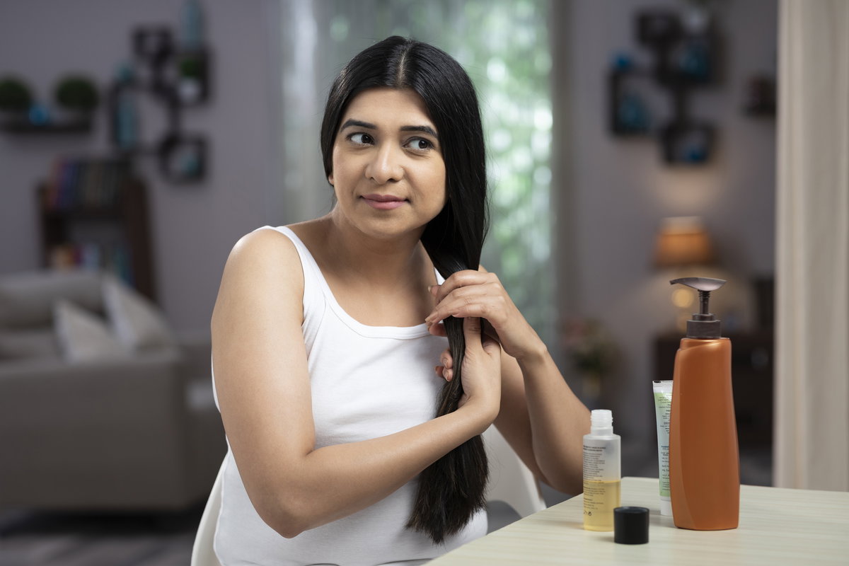 Frau ölt sich Haare ein
