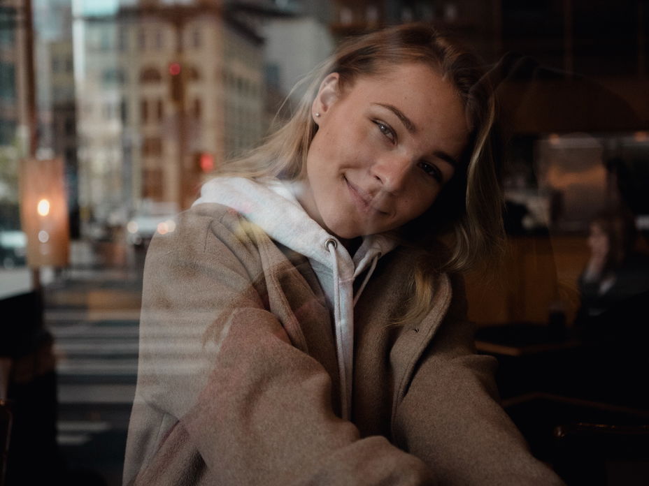 Junge Frau guckt aus dem Fenster