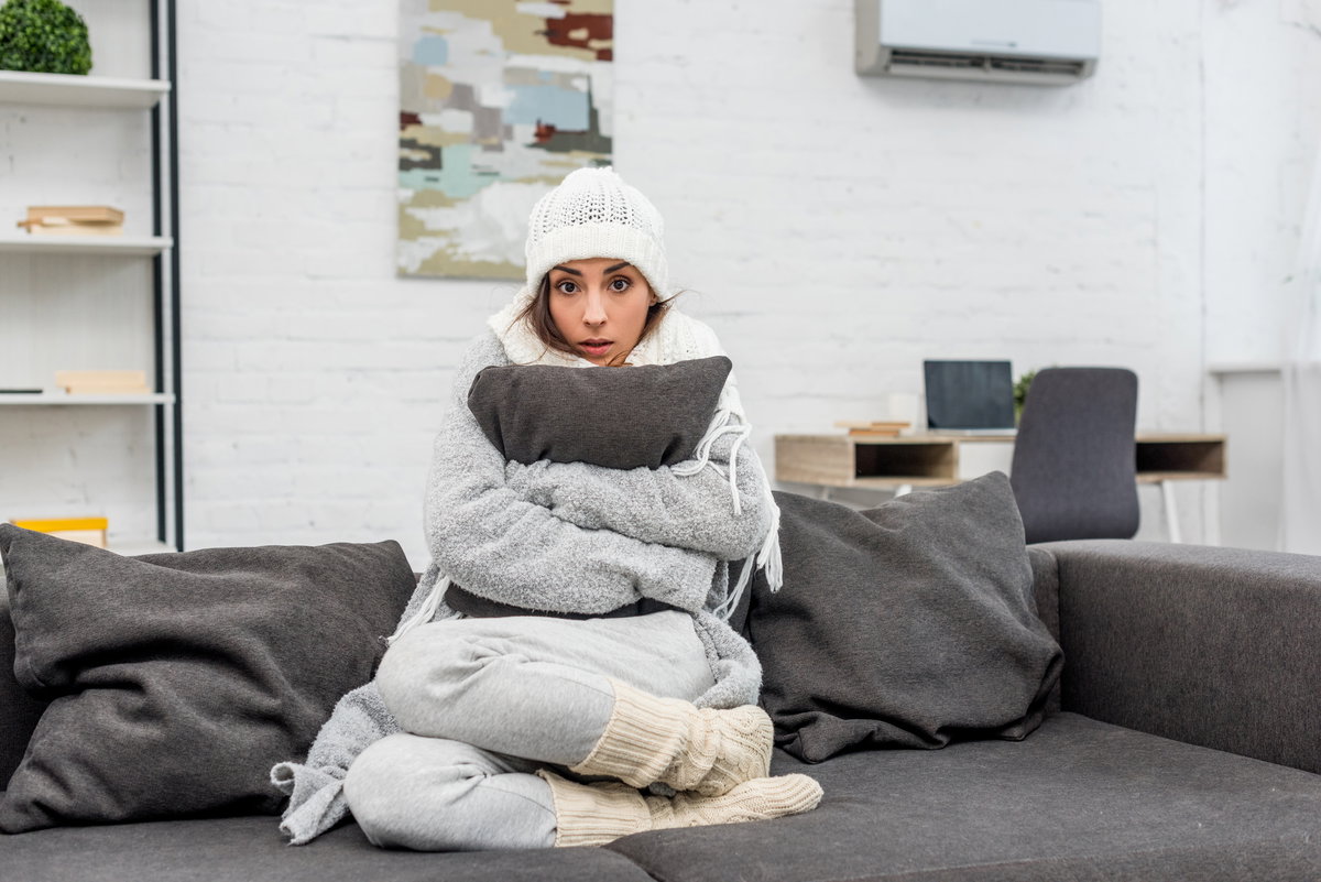 Frau friert in Wohnung