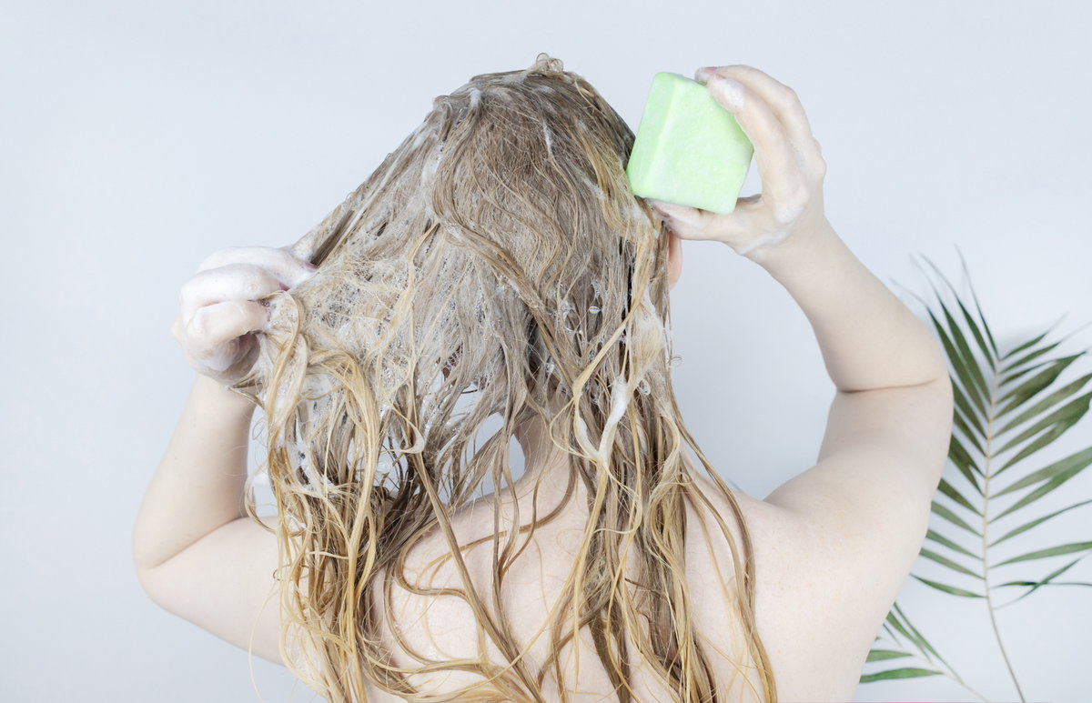 Frau benutzt festes Shampoo