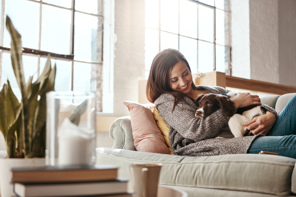 Frau mit Hund auf Sofa