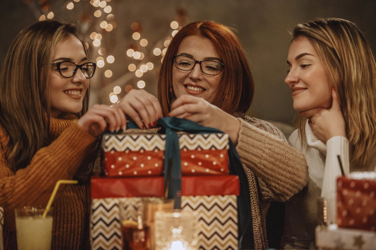 zwei junge Frauen mit Mutter und Weihnachtsgeschenken