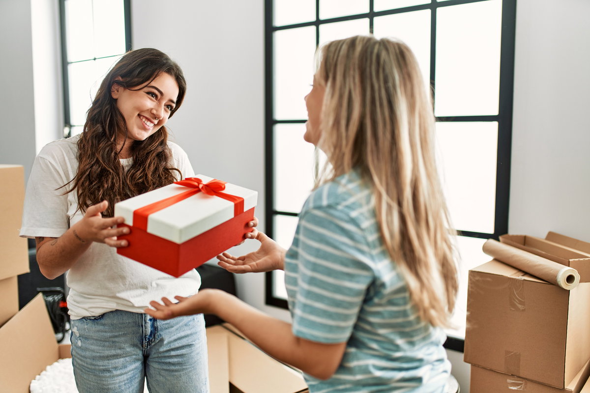 Frau schenkt Geschenk zum Einzug