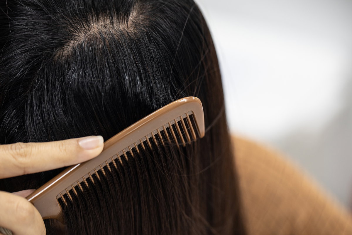 Frau kämmt Haare durch