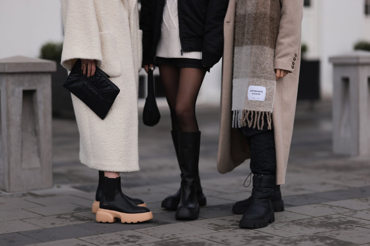 drei Frauen in Winter-Kleidung Mäntel und Stiefel