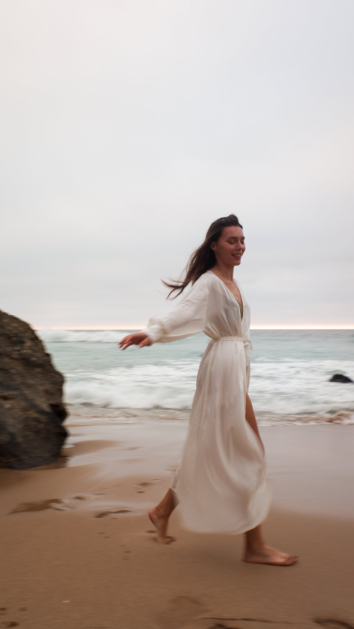 Frau steht am Strand
