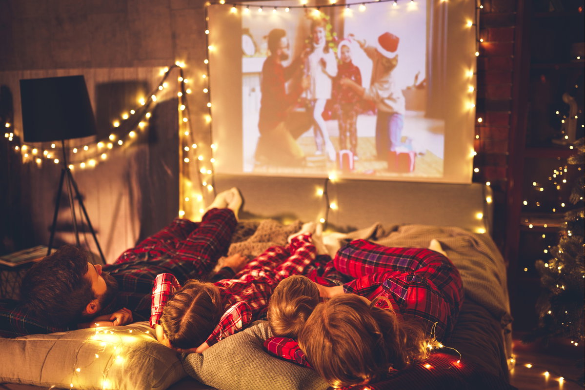 Familie schaut Weihnachtsfilme auf Beamer