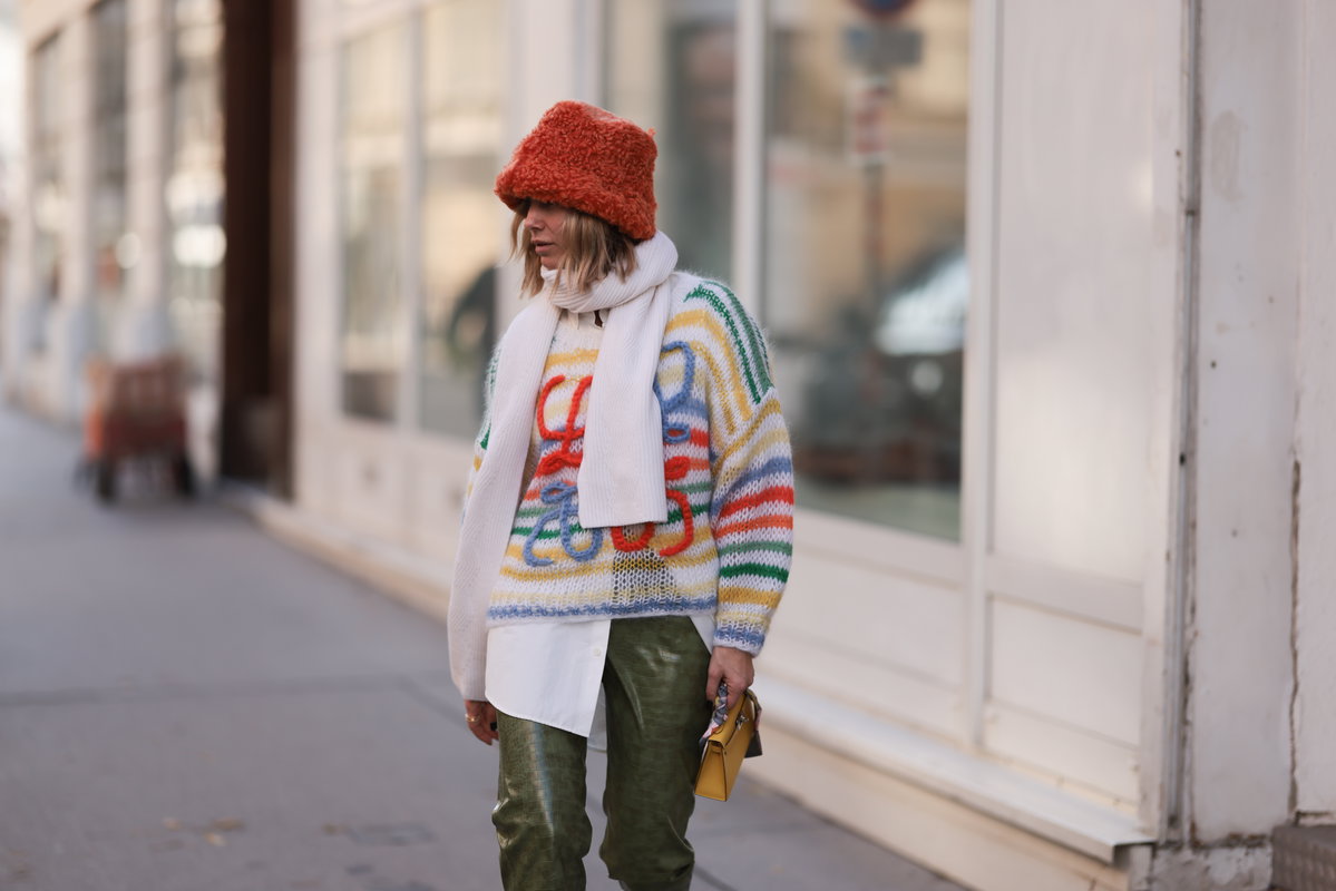 Frau mit rotem Hut und buntem Pullover