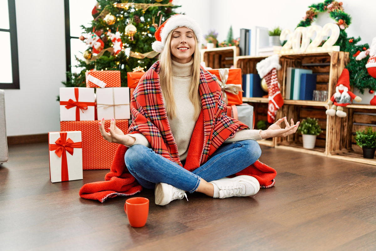 Frau meditiert vor dem Weihnachtsbaum