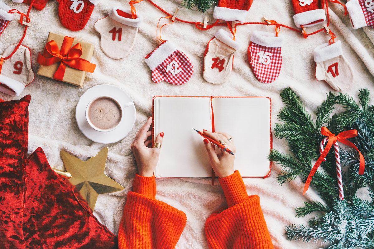Person schreibt in weihnachtliches Buch
