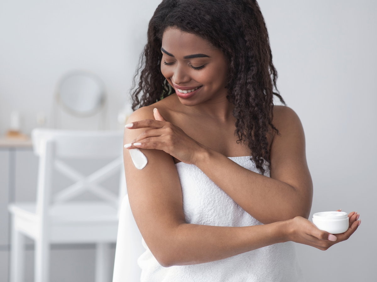 Frau trägt Bodylotion auf
