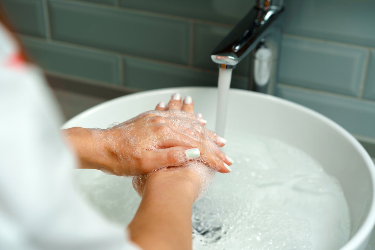 Frau hält Hände unter Wasser
