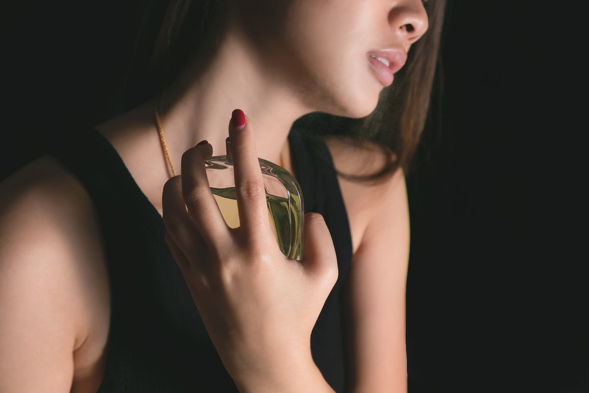 Frau sprüht Parfum auf