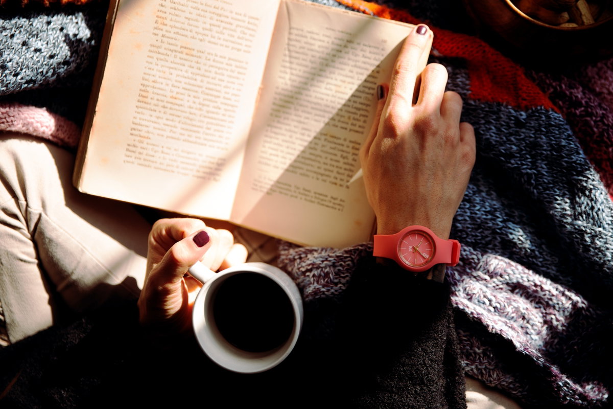 Buch und Kaffee in der Hand