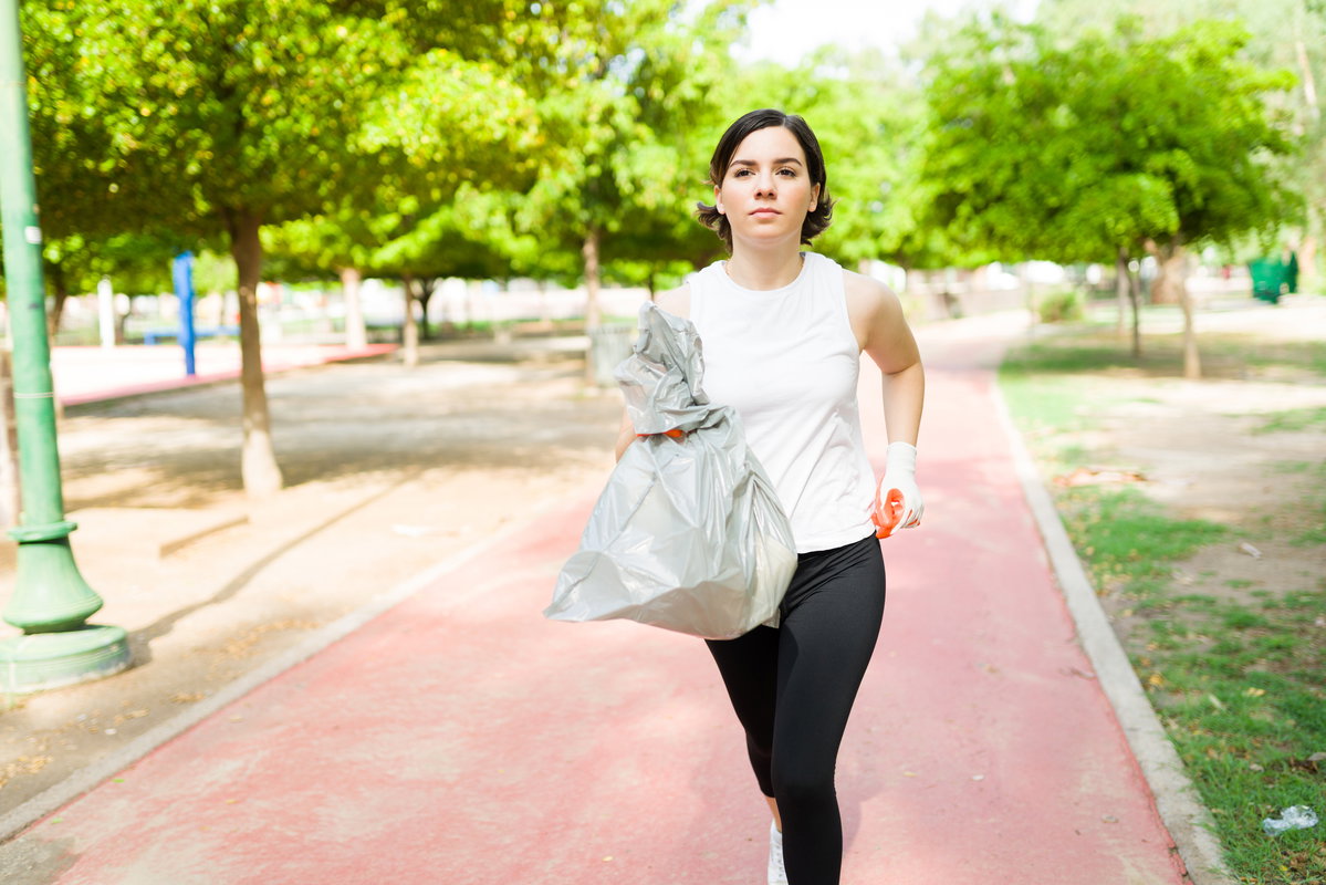 Frau läuft mit Mülltüte