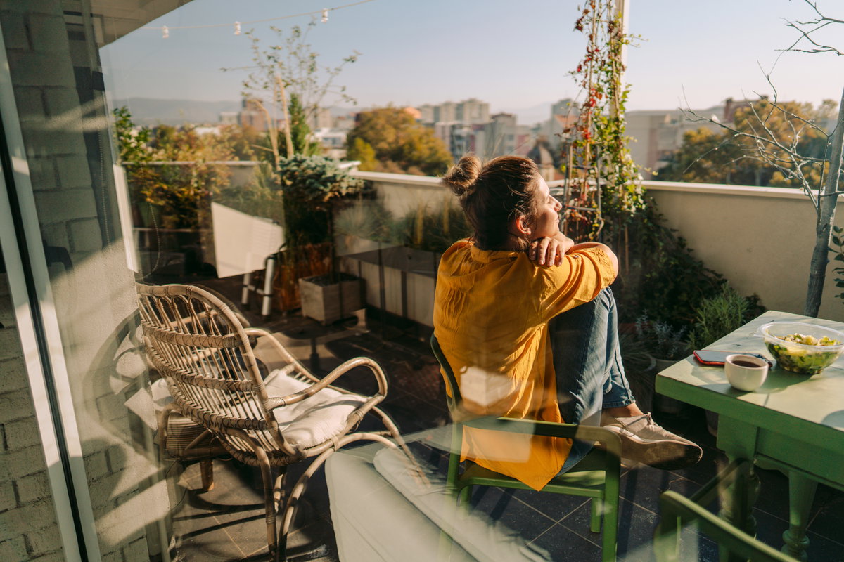 Junge Frau auf dem Balkon im Frühling