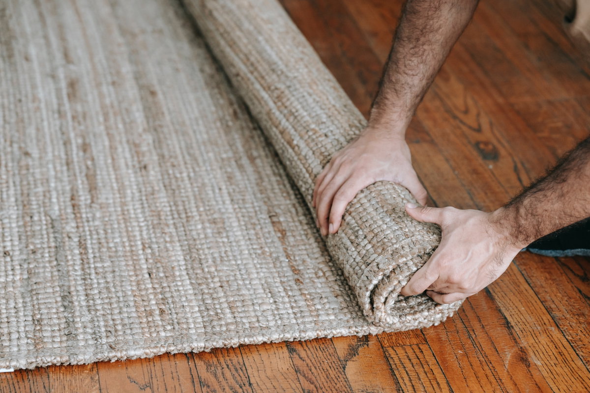 Person rollt Teppich aus