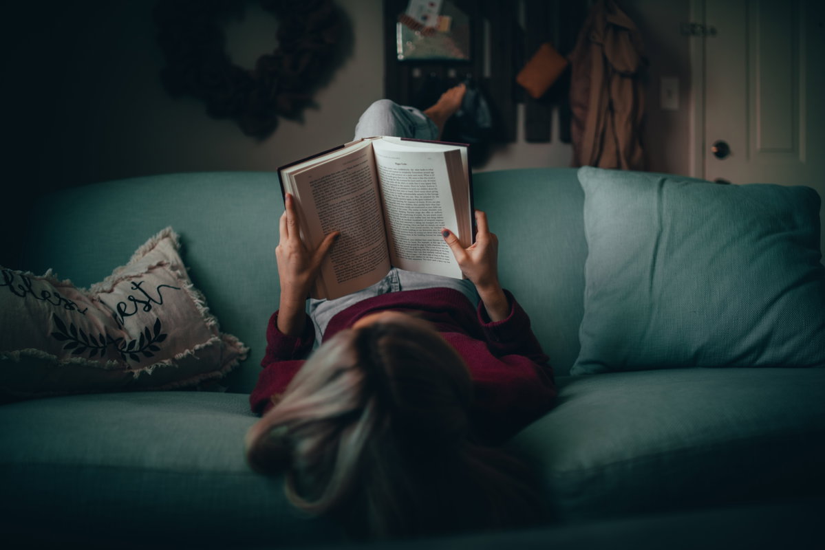 Frau liest auf der Couch