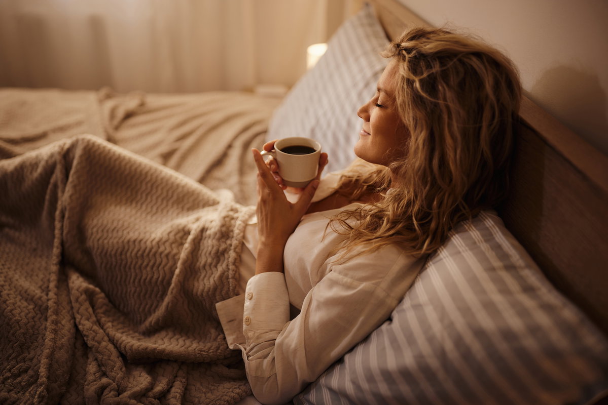 Junge Frau trink Tee im Bett