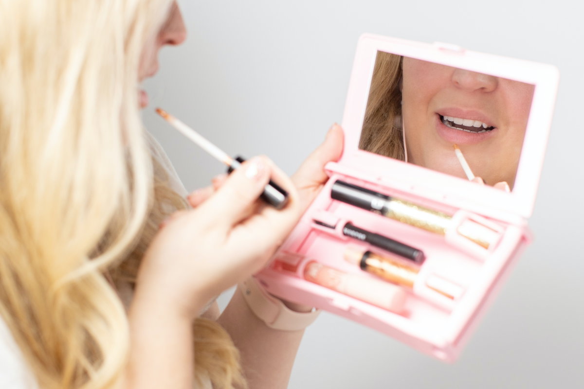 Frau trägt Lipgloss auf