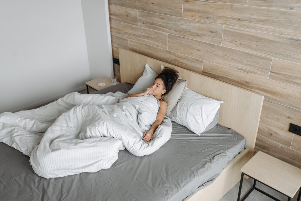 Frau im Bett mit Husten