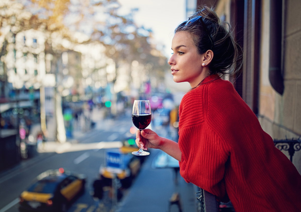 Frau mit Wein auf Balkon