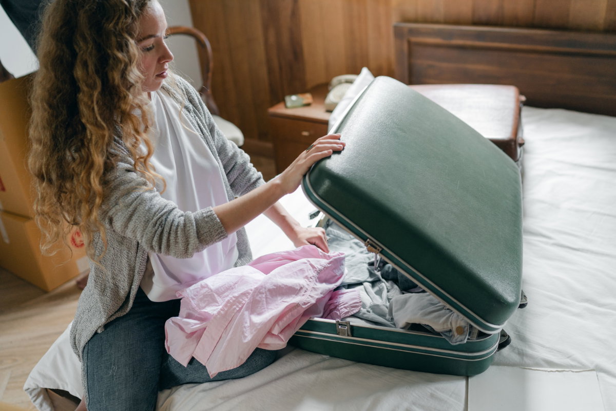 Frau packt ihren Koffer auf dem Bett