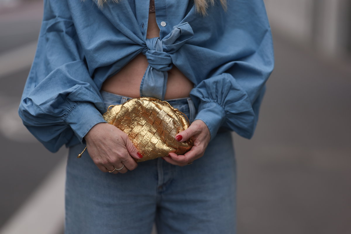 Frau trägt goldene Tasche