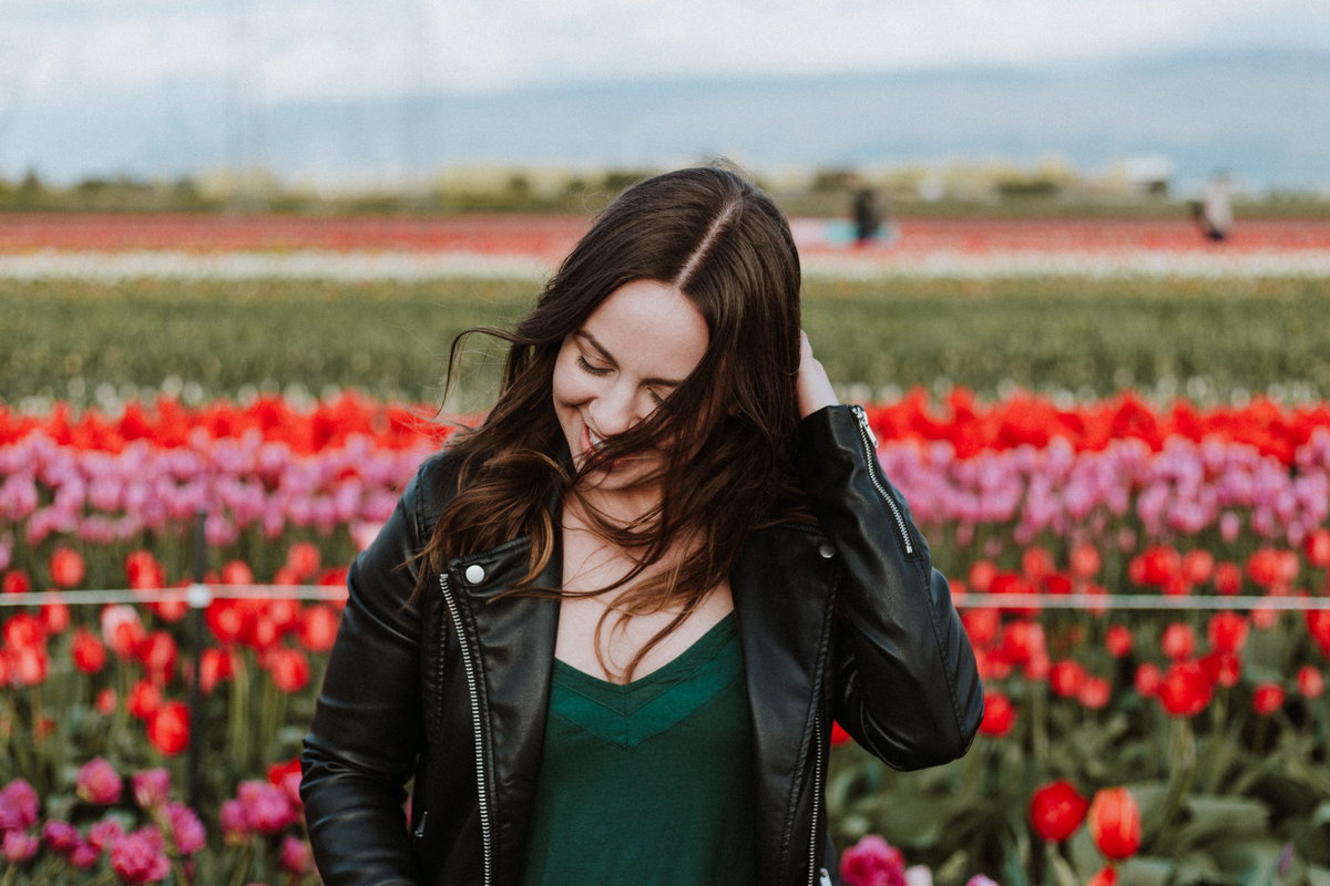 Frau lacht vor Blumenwiese