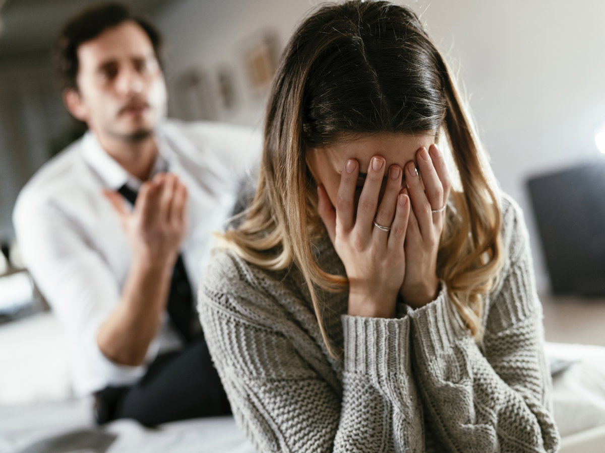 Frau hält Hände vors Gesicht
