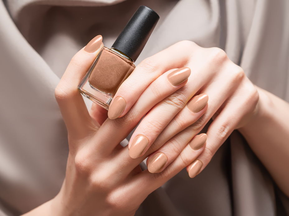 Person hält braunen Nagellack