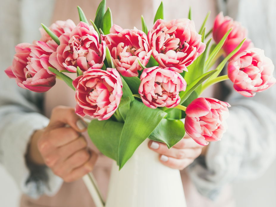 Frau drappiert Blumen in Vase