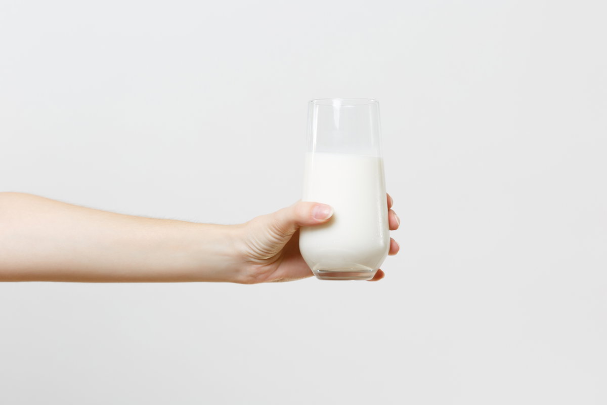 Frau hält Milch in der Hand
