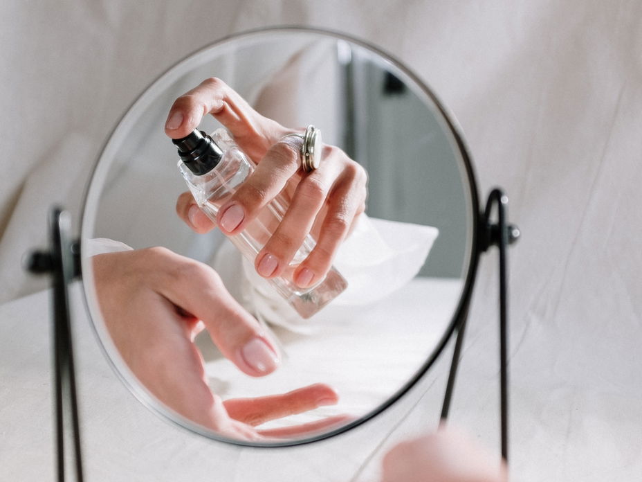Frau sprüht Parfum auf